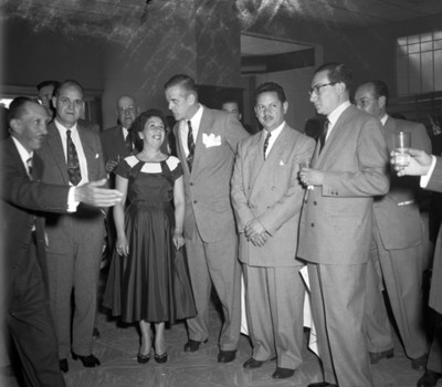 Hombres y mujer platican durante banquete en una agencia automotríz