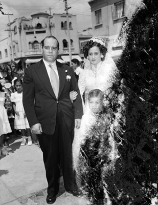 Novia toma del brazo a un hombre en el atrio de una iglesia durante su boda religiosa, retrato