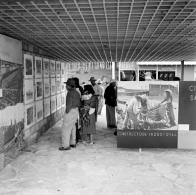Gente observan carteles, durante exposición de la Constructora Industrial Irolo