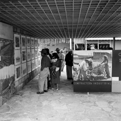 Gente observa carteles durante exposición de la Constructora Industrial Irolo