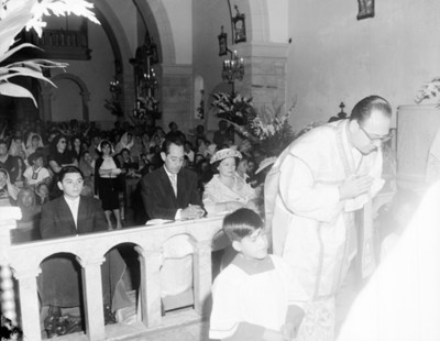Sacerdote y gente durante misa en una iglesia