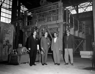 Hombres junto a máquinas en instalación industrial