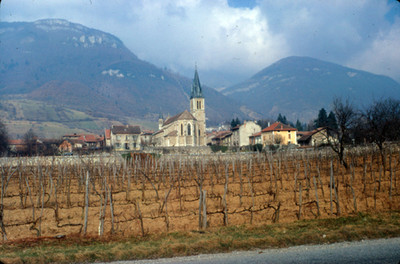 Poblado y su iglesia bajo el macizo montañoso de los Alpes