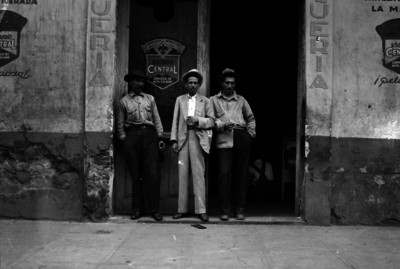 Hombres con bebida en la entrada de una pulquería, retrato de grupo