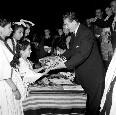 Adolfo López Mateos recibe un regalo de una niña durante el festival de la Guelaguetza