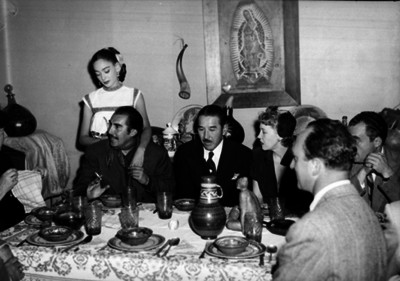 Emilio Indio Fernández conversando en la mesa durante una fiesta