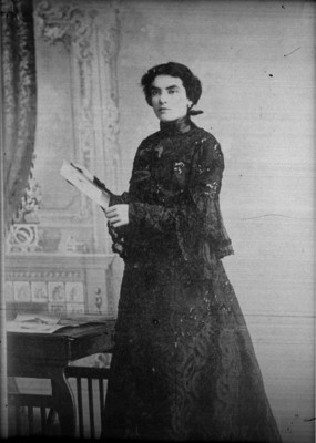 Esposa de Tomás Perete viendo una revista en una sala, retrato