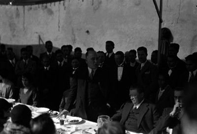 José Manuel Puig Casauranc pronunciando discurso ante otras personalidades durante un banquete