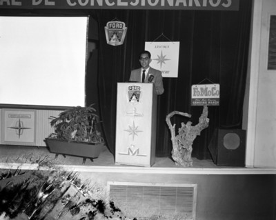 Hombre pronuncia discurso durante convención de concesionarios Ford