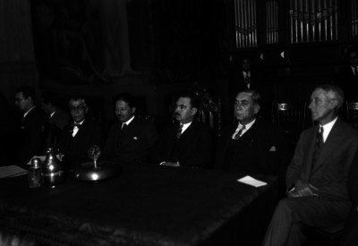 Aarón Sáenz con varias personalidades, presidiendo una ceremonia en un salón de actos de San Ildefonso