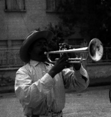 Hombre de sombrero tocando un tambor en la calle