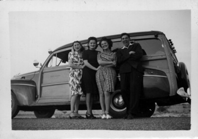 Familia de clase alta junto a su automóvil, retrato