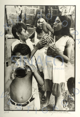 Mujer sostiene un loro junto a niños, retrato de grupo