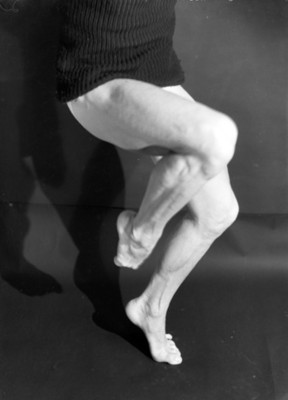 Piernas semi encogidas de un bailarin escenifican una expresión artistica