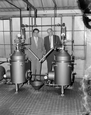 Hombres observan maquinaria durante obtención de aceite 1-2-3- en una fábrica