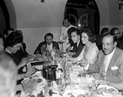 Hombres y mujeres comen durante banquete en un restaurante