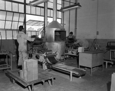 Hombres trabajan junto a una ventaneria de una fábrica