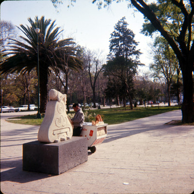 Hombre junto a escultura del Glifo de Chapultepec