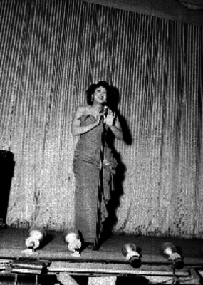 Mujer cantando en el escenario de un teatro