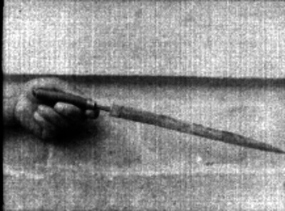 Mano sosteniendo un arma punzocortante