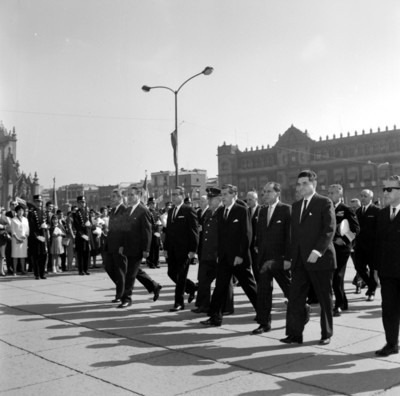 Adolfo López Mateos con miembros de su comitiva durante la ceremonia del día de la bandera en el zócalo de la cd. de México