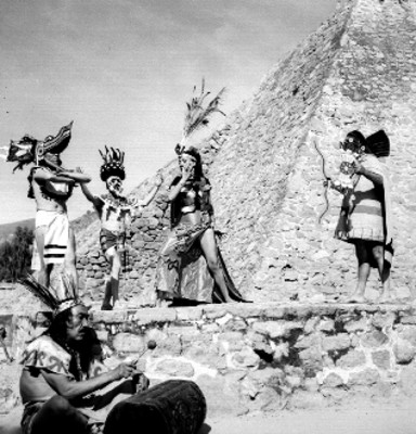 Bailarines con máscaras interpretando danza en la base de una pirámide