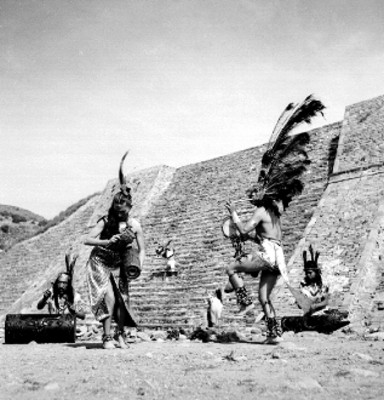 Bailarines en escena con instrumentos musicales representando una danza azteca al pie de la pirámide de Tenayucan