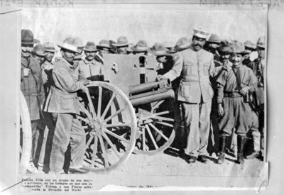 Francisco Villa y revolucionarios de pie con artillería, retrato de grupo