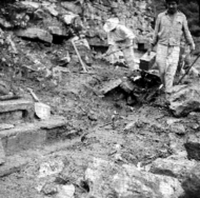 Hombres con pico y caja de herramientas en excavación arqueológica, Palenque