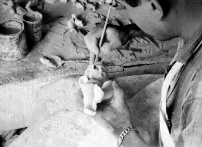 Artesano pinta un Niño Dios