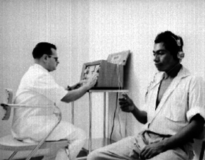 Médico realiza examén de oido a hombre