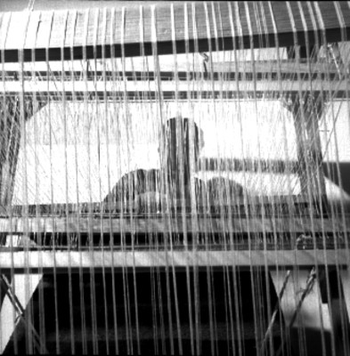 Hombre maneja un telar mecánico