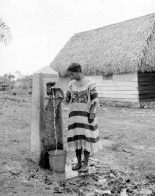 Mujer mazateca toma agua de una llave