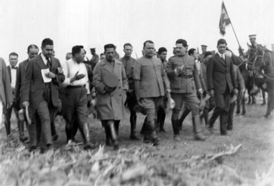 General Alvaro Obregón camina por un campo acompañado por otros militares