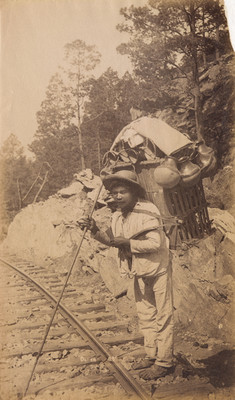 Ollero carga vasijas de barro a la orilla de vías férreas