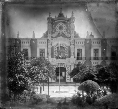 Gente sentada en bancas frente al Palacio Municipal