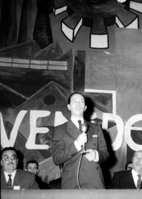 Antonio Ortiz Mena pronunciando un discurso en compañía de otras personalidades durante una ceremonia