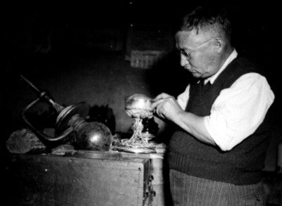 Artesano trabajando un caliz en el interior de un taller