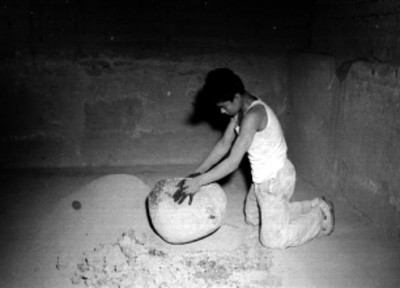 Artesano preparando horno para conchura de esculturas religiosas de barro en un taller de alfareria en Tonala