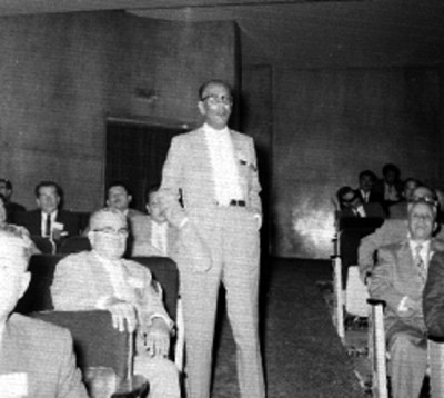 Comerciante haciendo uso de la palabra durante una reunión de la Confederación de Cámaras de Comercio en un auditorio