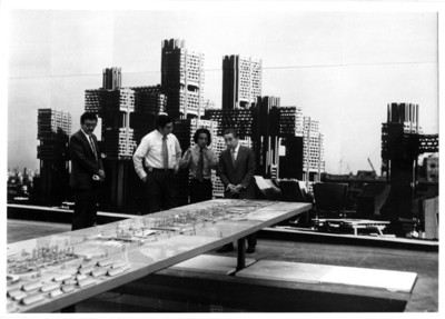 Alfonso Soto Soria y otras personas ante la maqueta del desarrollo arquitectónico de la bahía de Tokio, exposición temporal