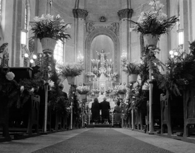 Novios hinchados frente a un altar durante su boda religiosa