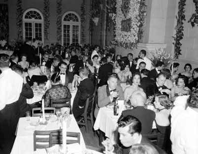 Hombres y mujeres durante banquete, vista parcial