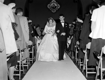 Novios caminan en el pasillo de una iglesia durante boda, retrato