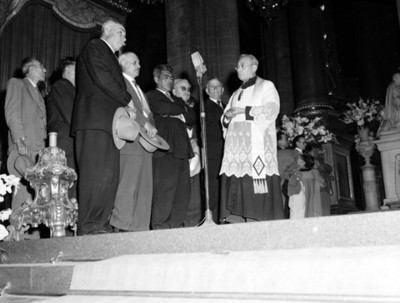Sacerdote y hombres durante ceremonia religiosa en una iglesia