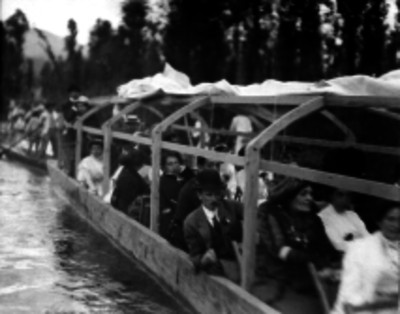 Personas en una trajinera por un canal de Xochimilco