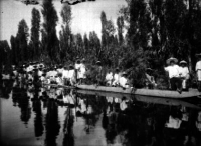 Hombres en trajineras por el canal de Xochimilco