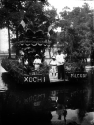 Hombres abordo de una trajinera por el canal de Xochimilco