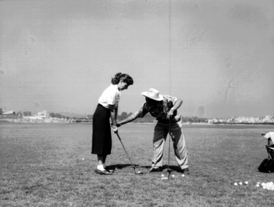 Juan Neri enseña a una mujer a jugar golf