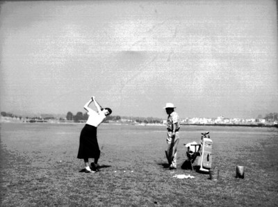 Juan Neri observa a una mujer durante una clase de golf